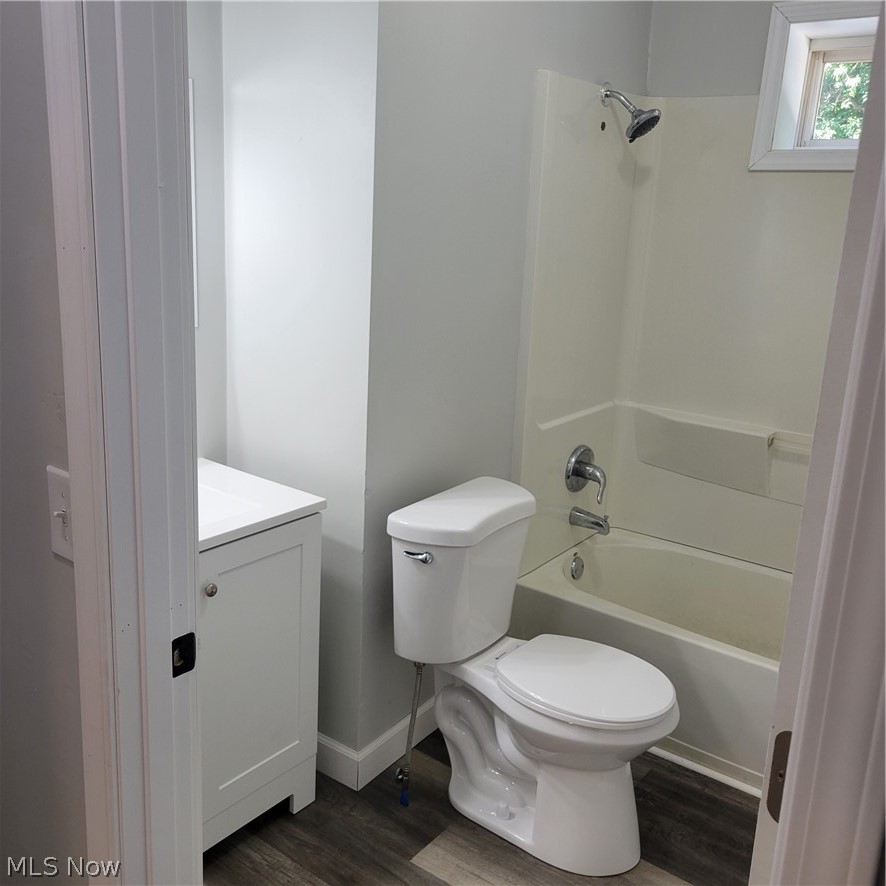1500 Warner Road Southeast Canton, OH 44707 - Photo 9 of 21 Full bathroom featuring vanity, washtub / shower combination, hardwood / wood-style flooring, and toilet