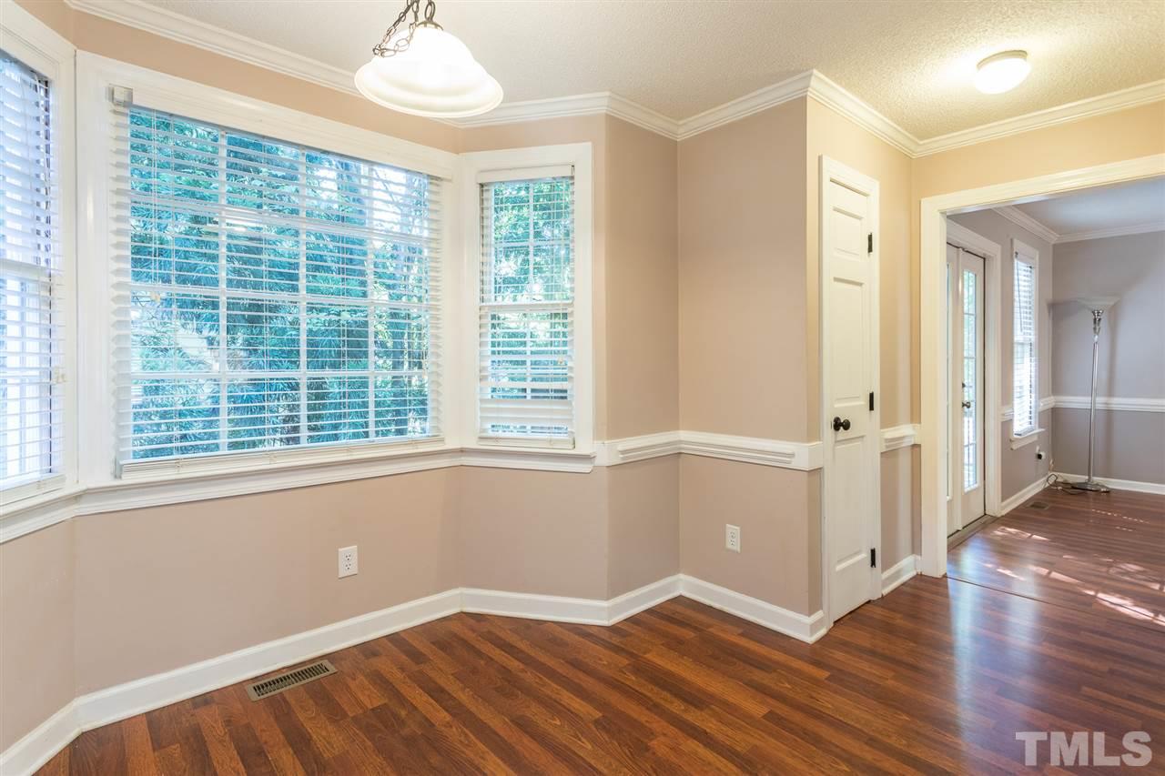 4513 Lancashire Drive Raleigh, NC 27613 - Photo 11 of 25 a view of an empty room with wooden floor and a window