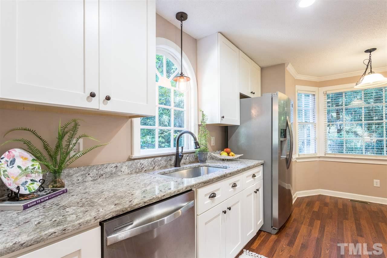 4513 Lancashire Drive Raleigh, NC 27613 - Photo 7 of 25 a kitchen with stainless steel appliances granite countertop a sink a stove and a wooden floor