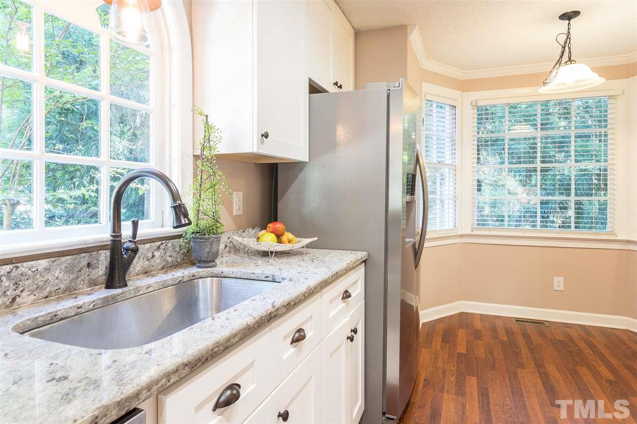 4513 Lancashire Drive Raleigh, NC 27613 - Photo 8 of 25 a kitchen with granite countertop a sink a counter and a window