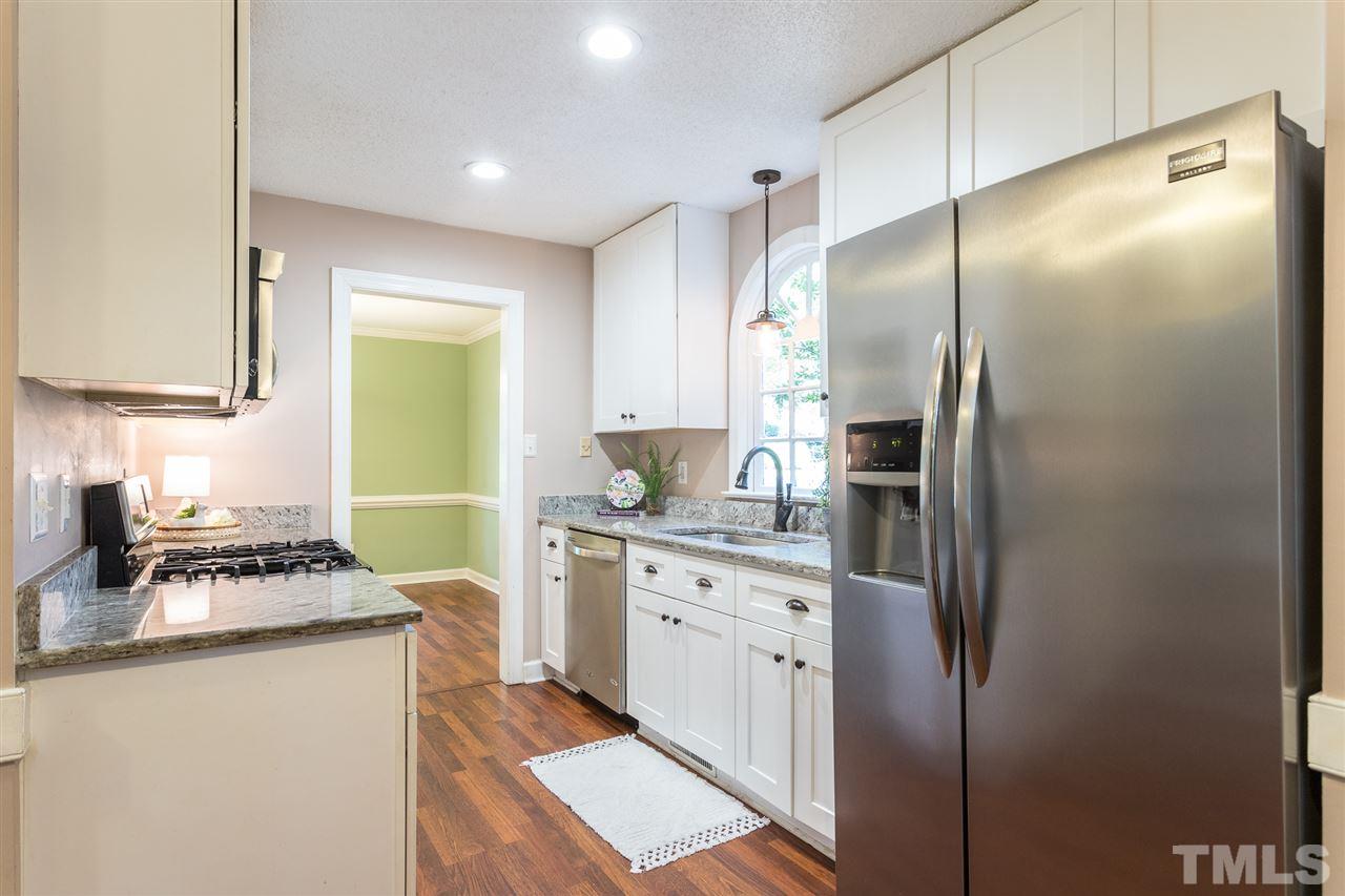 4513 Lancashire Drive Raleigh, NC 27613 - Photo 9 of 25 a kitchen with stainless steel appliances a refrigerator sink and stove