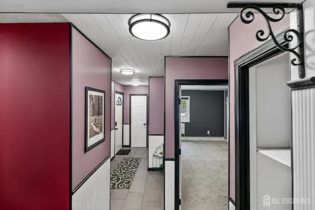 a view of a hallway with entryway and wooden floor