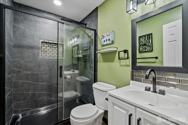 a bathroom with a sink a toilet and shower