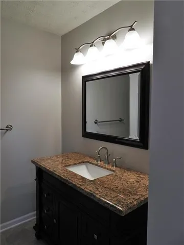 a bathroom with a granite countertop sink and mirror