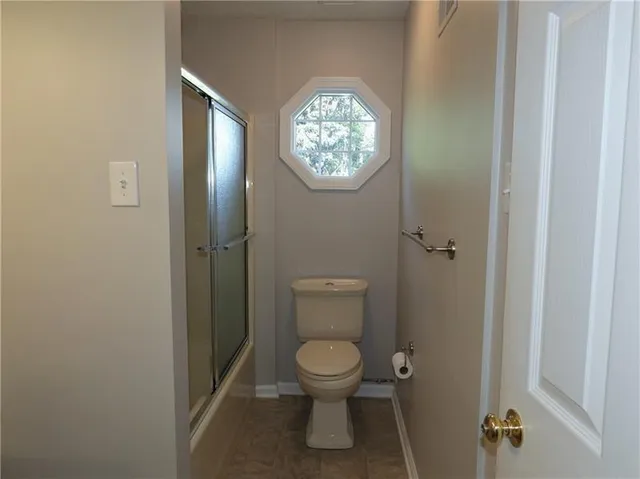 a bathroom with a toilet and a shower