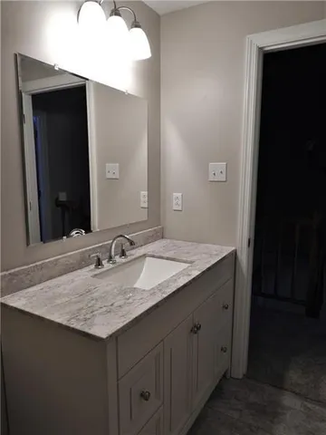 a bathroom with a granite countertop sink and a mirror