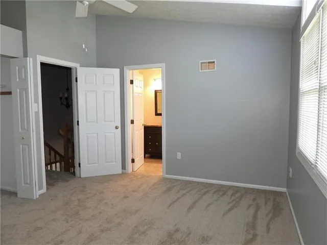 an empty room with windows and closet