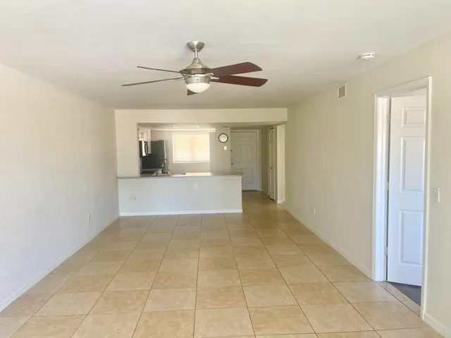 a view of a livingroom with a chandelier fan and windows