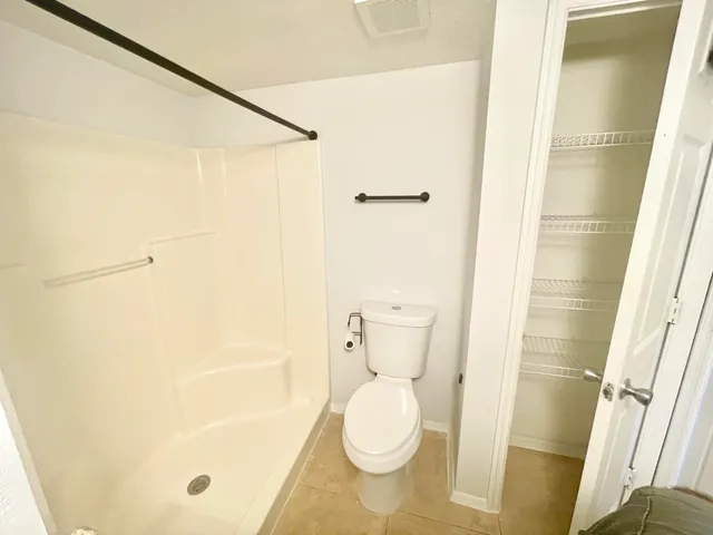 a bathroom with a toilet and a shower