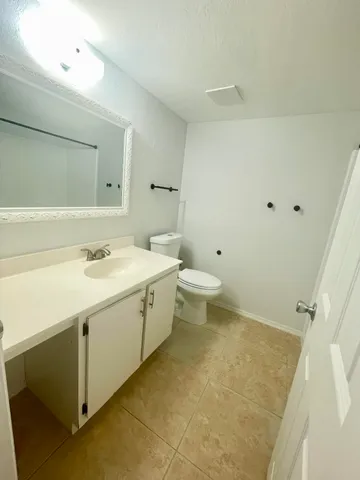 a spacious bathroom with a sink a toilet and a mirror