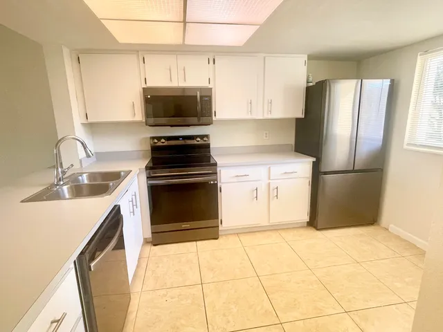 a kitchen with stainless steel appliances granite countertop a refrigerator stove and sink