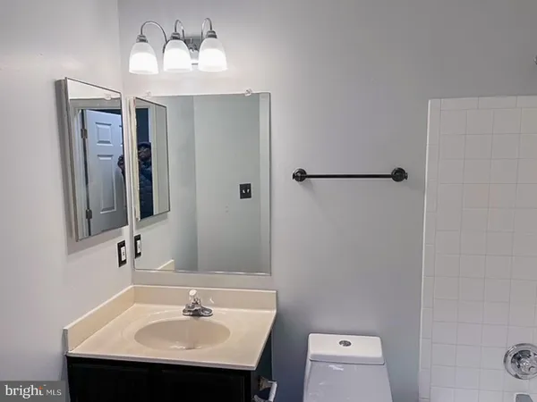 a bathroom with a sink a light fixture and a mirror