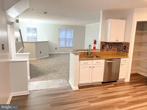 a view of a kitchen with wooden floor and electronic appliances