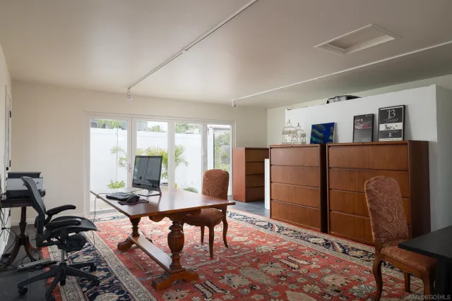 a living room with furniture a flat screen tv and a refrigerator