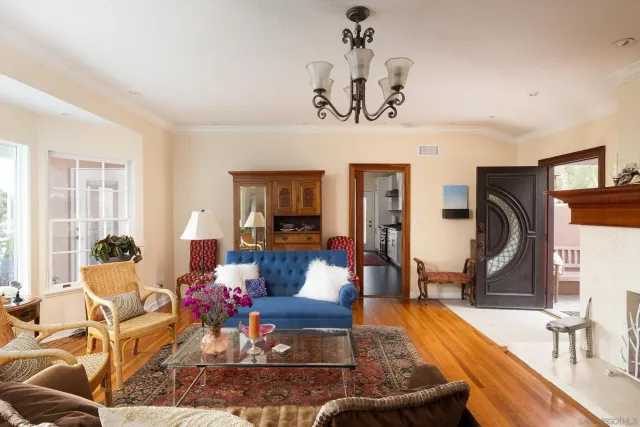 a living room with furniture chandelier and a large window