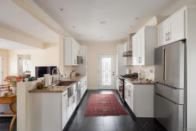 a kitchen with refrigerator a stove top oven a sink dishwasher and wooden cabinets