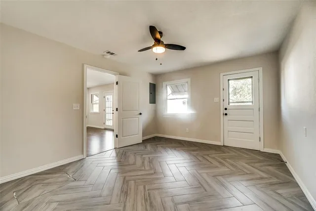a view of empty room with wooden floor and window