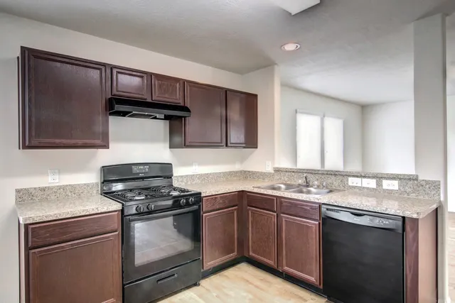a kitchen with stainless steel appliances a sink stove and cabinets
