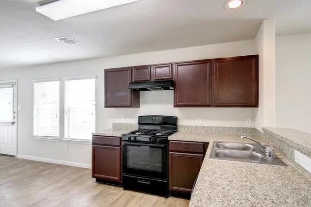 a kitchen with granite countertop a stove and a sink
