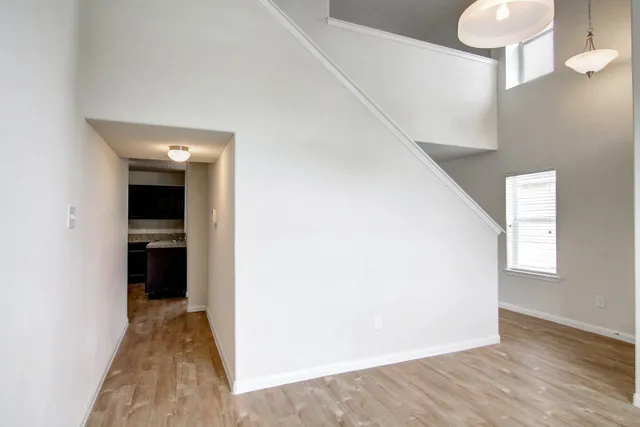 a view of a hallway with wooden floor and staircase