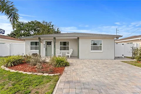 a front view of house with yard and trees around