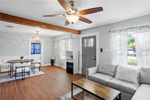 a living room with furniture and a wooden floor