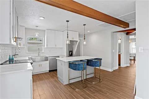 a kitchen with a sink cabinets and wooden floor