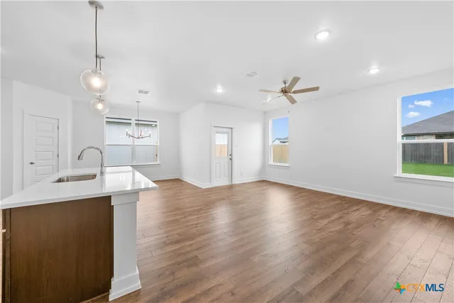 a view of kitchen with sink microwave refrigerator and cabinets