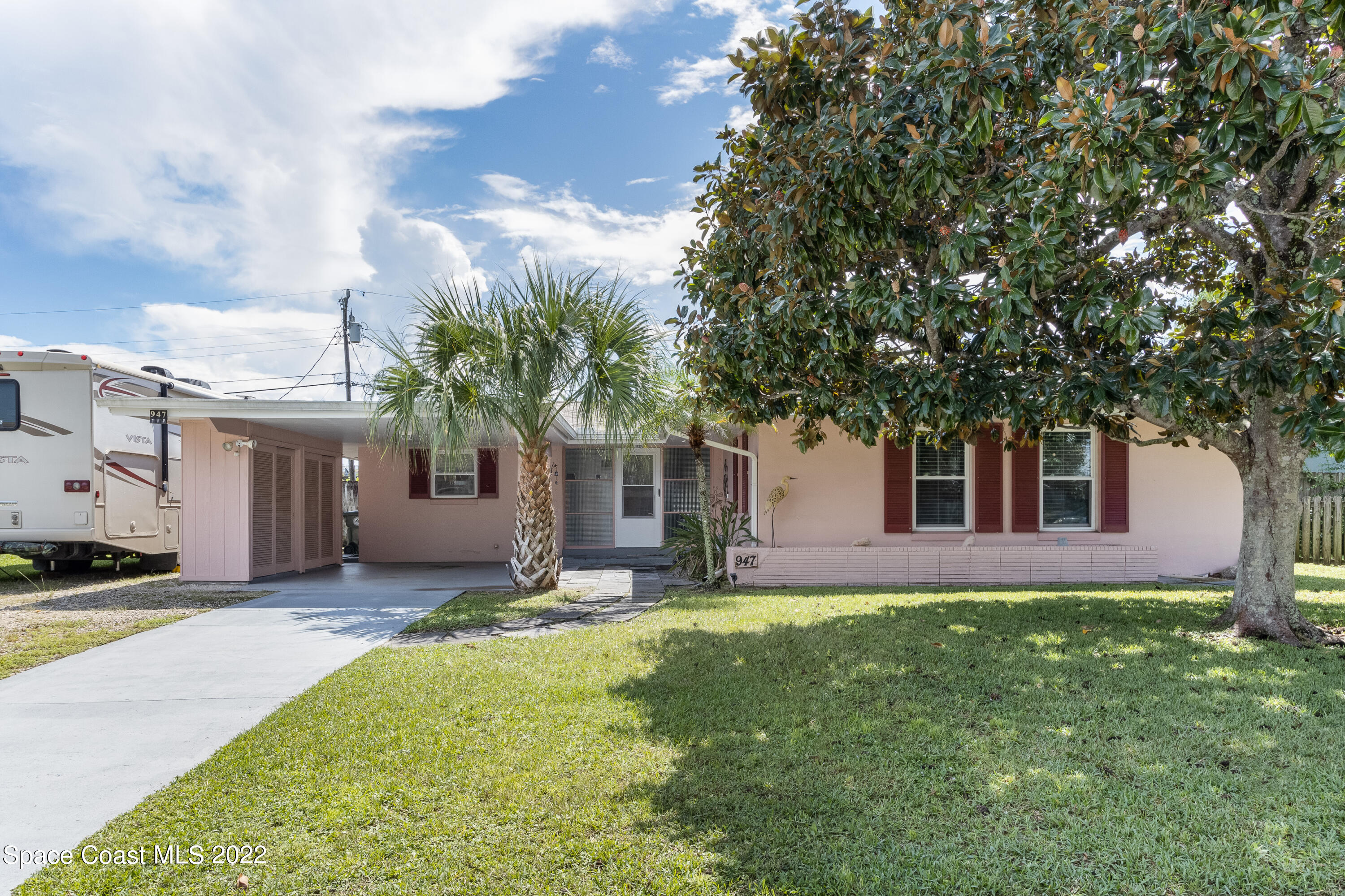 947 Brunswick Lane Rockledge, FL 32955 - Photo 2 of 22 a front view of a house with a garden and trees