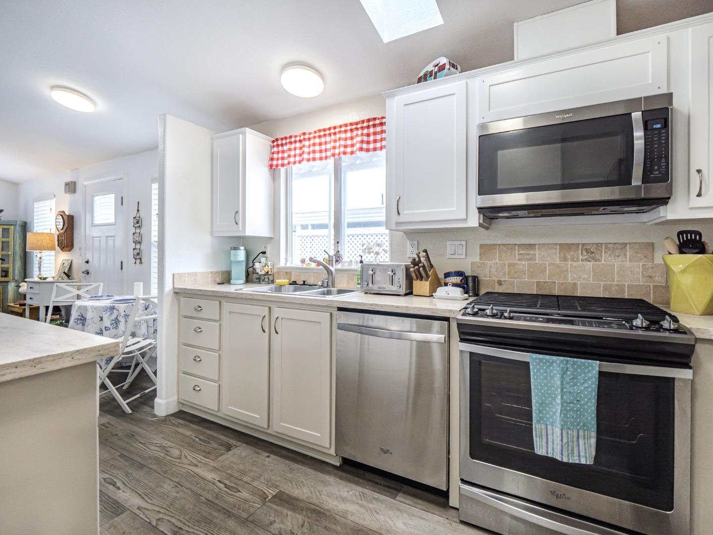 100 North Rodeo Gulch Road, Unit 65 Soquel, CA 95073 - Photo 12 of 24 a kitchen with cabinets stainless steel appliances and wooden floor