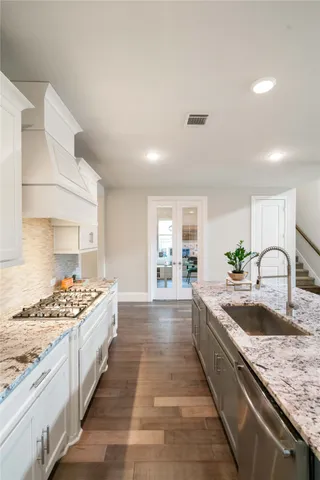 a large kitchen with stainless steel appliances granite countertop a lot of counter space and wooden floors