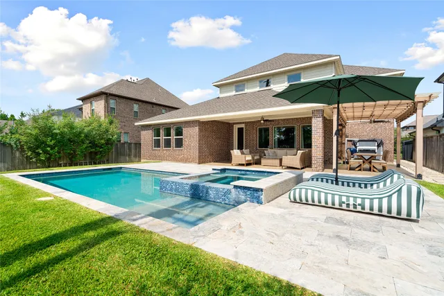 a view of a house with swimming pool and porch with furniture