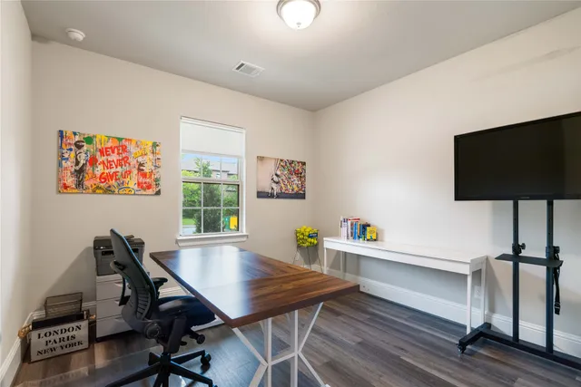 a view of a workspace with furniture and a flat screen tv