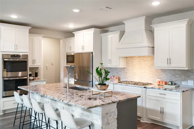 a kitchen with stainless steel appliances granite countertop a stove refrigerator sink and cabinets