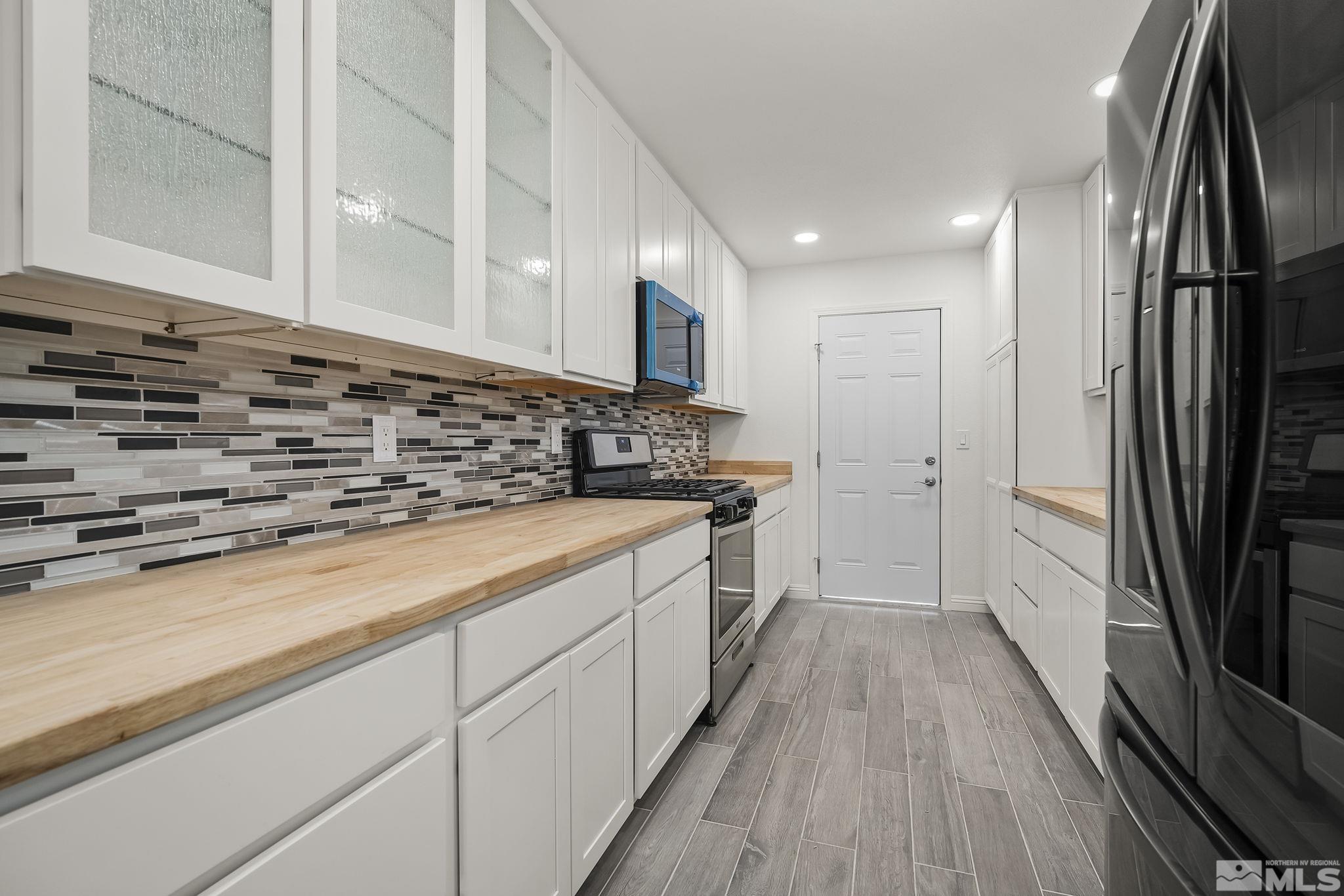 10029 Humite Lane Reno, NV 89506 - Photo 7 of 15 a kitchen with stainless steel appliances a sink stove and refrigerator