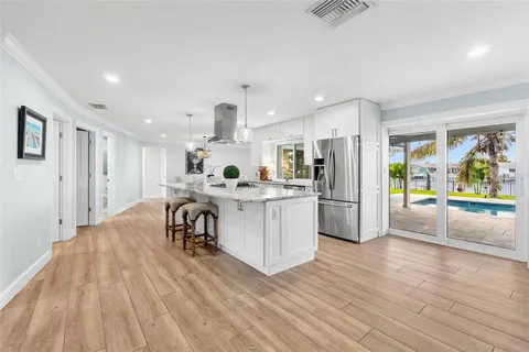 a large kitchen with stainless steel appliances granite countertop a lot of counter space and a sink