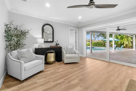 a view of an empty room with wooden floor and a ceiling fan