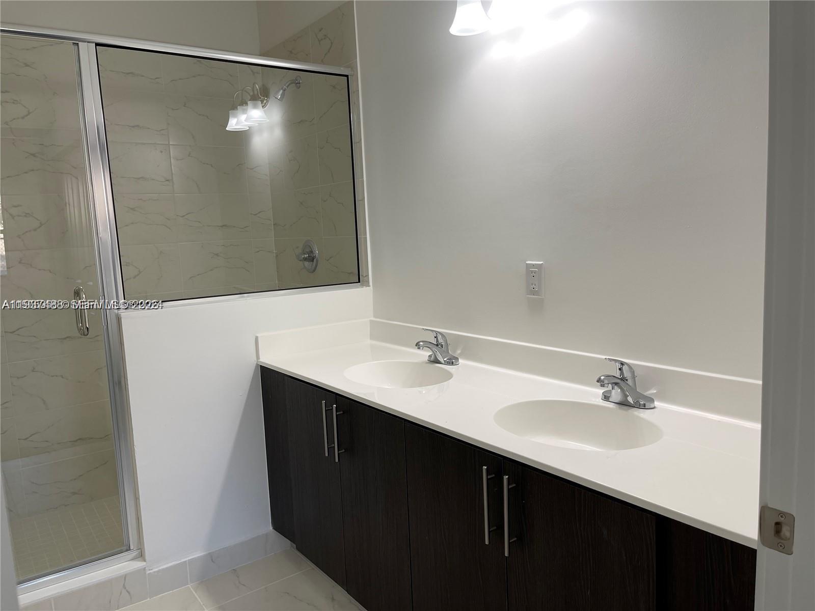 15520 Southwest 136th Street, Unit 104 Miami, FL 33196 - Photo 12 of 13 a bathroom with a sink and a mirror