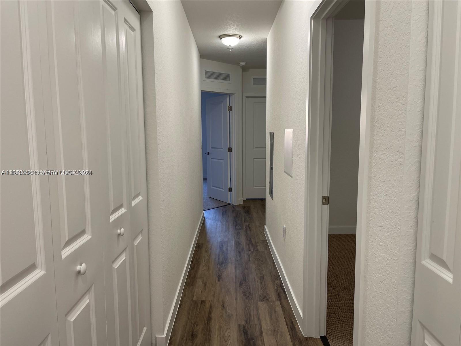 15520 Southwest 136th Street, Unit 104 Miami, FL 33196 - Photo 9 of 13 a view of a hallway with wooden floor