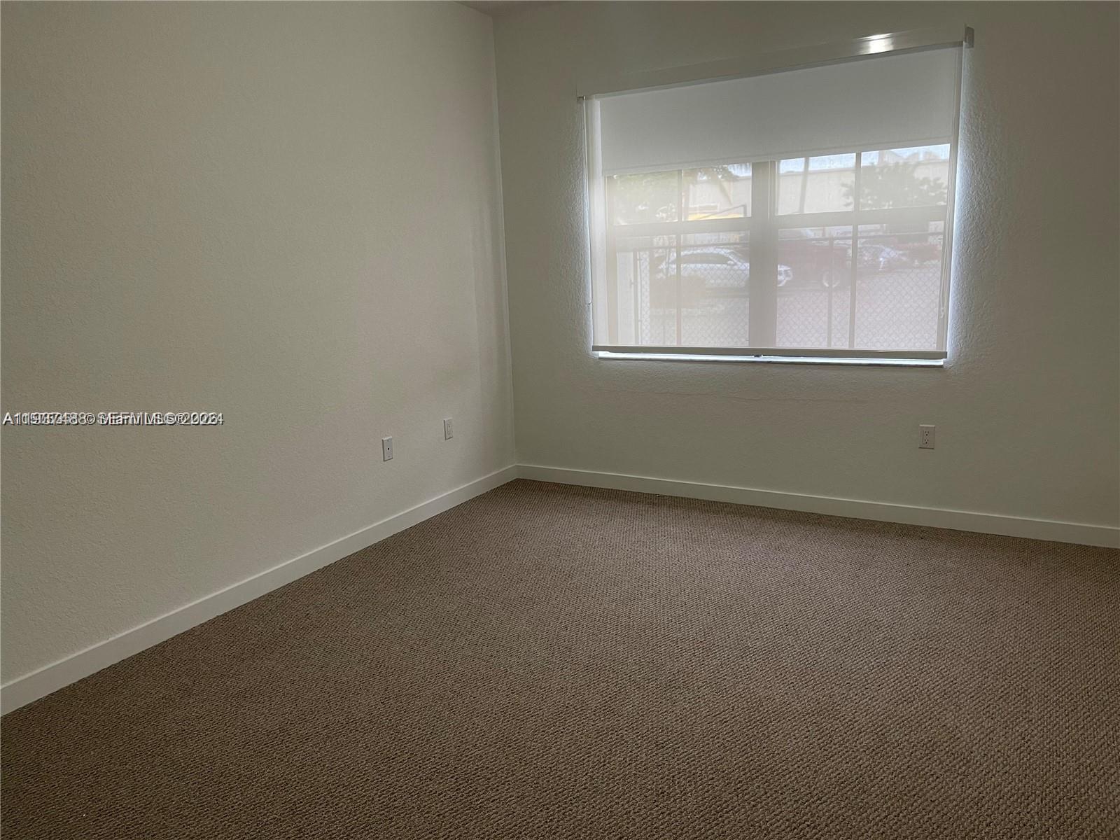 15520 Southwest 136th Street, Unit 104 Miami, FL 33196 - Photo 10 of 13 an empty room with a window