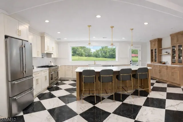 a kitchen with a refrigerator a sink and white cabinets