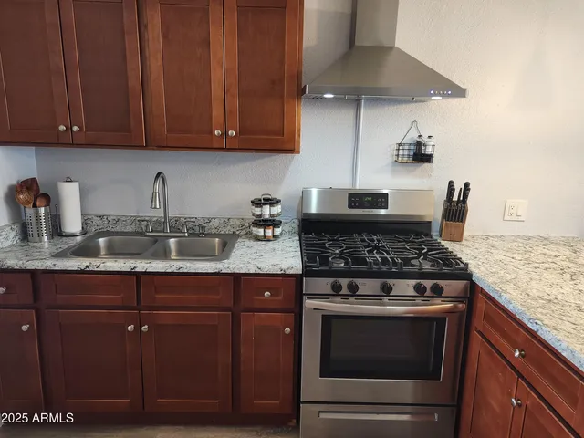 a stove top oven sitting inside of a kitchen and granite counter tops