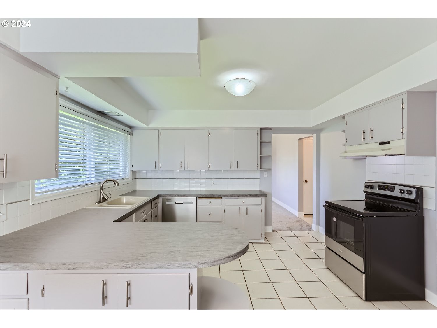 9386 Southwest 35th Avenue Portland, OR 97219 - Photo 13 of 29 a kitchen with a sink a stove and cabinets