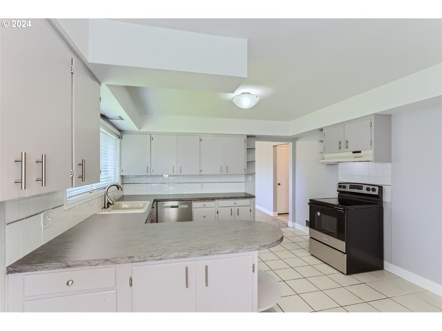 9386 Southwest 35th Avenue Portland, OR 97219 - Photo 14 of 29 a kitchen with granite countertop a sink and a stove top oven