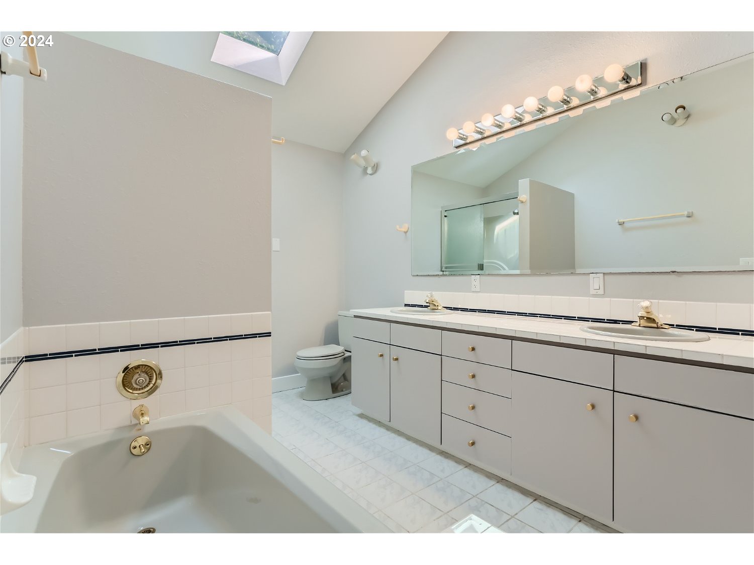 9386 Southwest 35th Avenue Portland, OR 97219 - Photo 21 of 29 a bathroom with a double vanity sink a mirror and a toilet