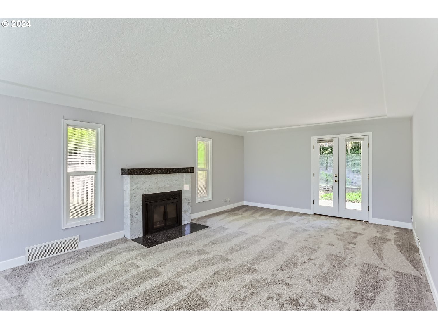 9386 Southwest 35th Avenue Portland, OR 97219 - Photo 5 of 29 an empty room with windows and fireplace