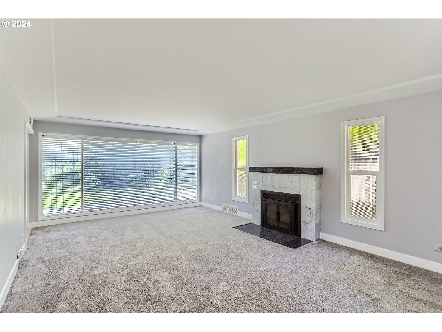 9386 Southwest 35th Avenue Portland, OR 97219 - Photo 6 of 29 a view of empty room with window and fireplace