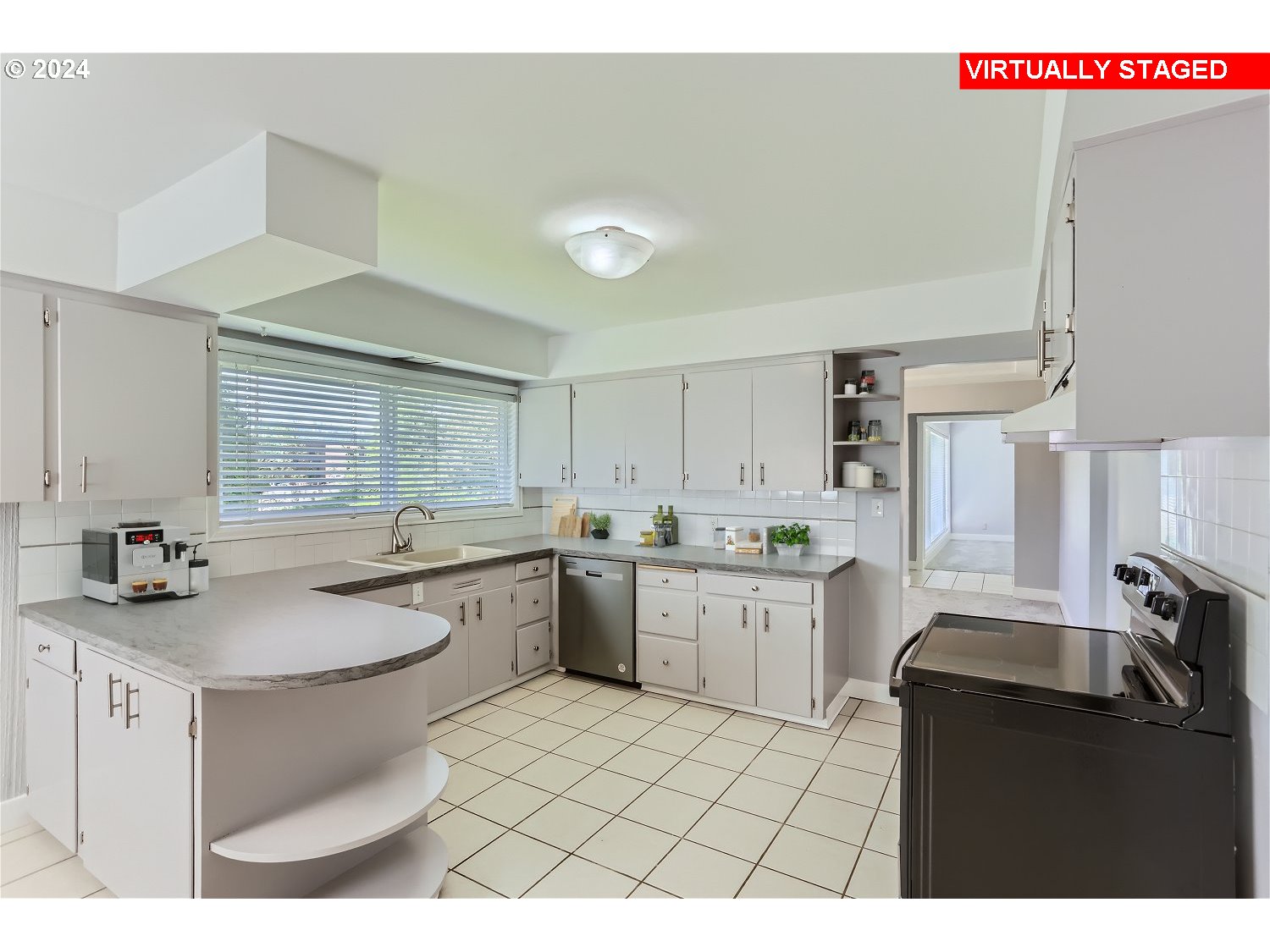 9386 Southwest 35th Avenue Portland, OR 97219 - Photo 10 of 29 a kitchen with a sink a stove a refrigerator and white cabinets