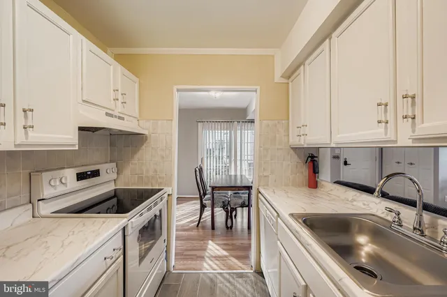 a kitchen with granite countertop a sink stove and cabinets