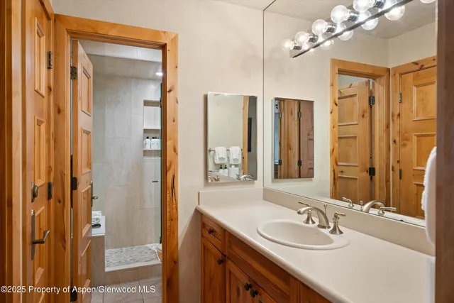 a bathroom with a granite countertop sink a toilet and shower